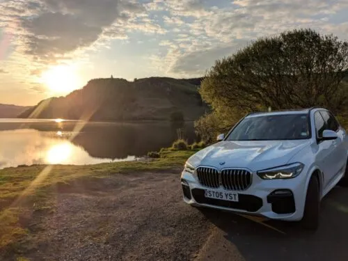 BMW X5 parked near a beach